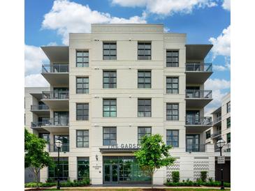 The Gadsden multi-story building featuring a light brick facade, balconies, and manicured landscaping at 5 Gadsdenboro St # 204, Charleston, SC 29401