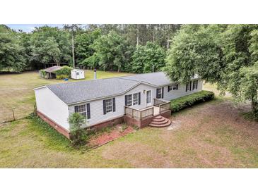 Charming single-story home with white siding, black shutters, and a cozy front deck at 5056 Red Oak Rd, Cottageville, SC 29435