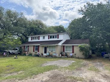 Charming two-story home features a landscaped front yard with mature trees and colorful window shutters at 759 Powhatan Ave, Mount Pleasant, SC 29464