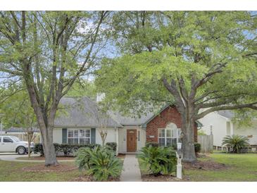 Charming single-story home featuring a well-manicured lawn, mature trees, and inviting curb appeal at 8774 Adaline St, North Charleston, SC 29406