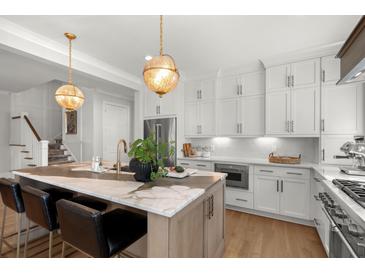 Bright, updated kitchen with a marble island, stainless appliances, and modern hanging lights at 9822 Haven Loop, Johns Island, SC 29455