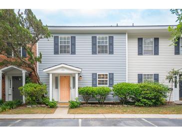 Charming townhome with light blue siding, black shutters, tidy landscaping, and a peach-colored front door at 153 Heritage Cir # K3, Mount Pleasant, SC 29464