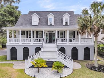 Stunning two-story home featuring a grand entrance, double staircases, and a charming front porch at 1711 Indigo Island Dr, Hanahan, SC 29410