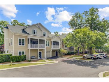 Inviting two-story townhomes with covered porches and attached garages on a sunny day at 2121 Egret Crest Ln, Charleston, SC 29414