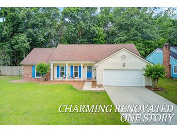Charming one-story home with a manicured lawn, bright blue accents, and inviting front porch seating at 300 Hamlet Rd, Summerville, SC 29485
