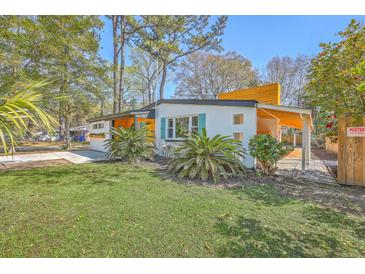Charming single-story home with a well-manicured lawn, palm trees, and a unique architectural design at 32 Briarcliff Dr, Charleston, SC 29407