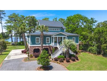 Stunning raised home featuring mature landscaping, covered parking, and beautiful lake views at 423 Lake Moultrie Dr, Bonneau, SC 29431