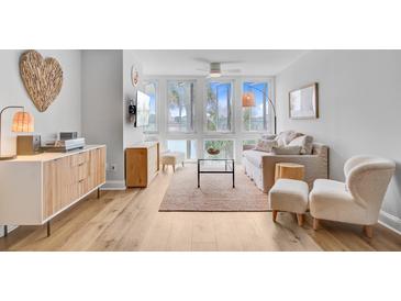Bright living room features light hardwood floors and plush seating near large windows offering beautiful waterfront views at 5 Mariners Cay Dr, Folly Beach, SC 29439