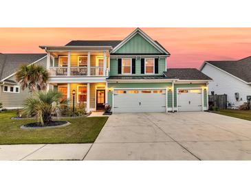 Two-story green home boasts a spacious three-car garage and charming second-story balcony at 658 Yellow Leaf Ln, Summerville, SC 29486