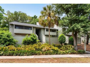Inviting condo with lush landscaping, palm tree and charming two-story facade, perfect for low-maintenance living at 1142 Village Creek Ln # 4, Mount Pleasant, SC 29464