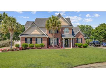 Beautiful two-story brick home with manicured lawn, mature landscaping, and a welcoming front entrance at 1503 Pondside Ct, Summerville, SC 29485