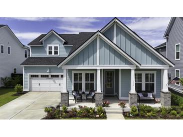 Charming two-story home featuring a covered front porch, a well-maintained lawn, and an attached two-car garage at 172 Helena Park Dr, Summerville, SC 29486