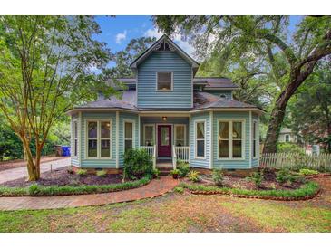 Charming two-story home with light blue siding, bay windows, brick walkway, and mature landscaping at 1830 Kempton Ave, James Island, SC 29412
