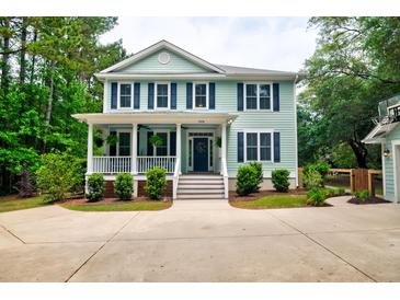Charming two-story home with light-blue siding, white trim, and a welcoming front porch at 1976 Liberia Rd, Wadmalaw Island, SC 29487