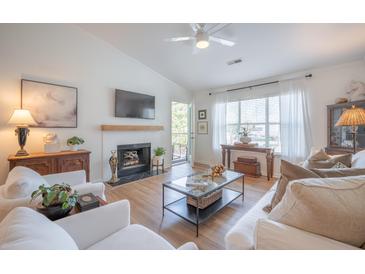 Bright living room with white furniture, fireplace, mounted tv, and lots of natural light at 2011 N Highway 17 # 2300F, Mount Pleasant, SC 29466
