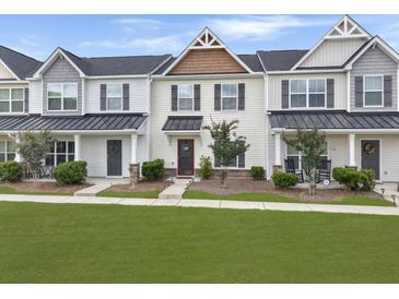 Charming townhouse featuring a covered entry, landscaped yard, and welcoming front door at 312 Silverdrop St, Goose Creek, SC 29445