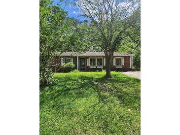 Charming single-story brick home featuring lush lawn and mature trees in a tranquil setting at 33 Roselle Ave, Goose Creek, SC 29445