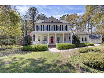 Inviting two-story home with a charming front porch and a bright red front door at 4233 Lady Banks Ln, Ravenel, SC 29470