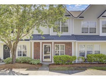 Inviting townhome with brick accents, manicured landscaping, and a covered entryway at 302 Elm Hall Cir, Summerville, SC 29483