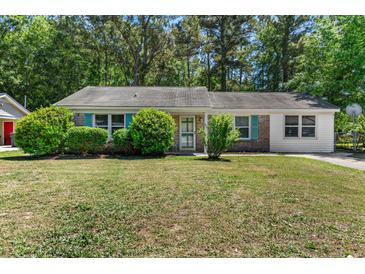 Charming single-story home features lush front yard and a mix of brick and siding exterior at 3249 Stonehaven Dr, North Charleston, SC 29420