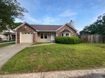 Charming brick home featuring a well-maintained lawn, attached garage, and beautiful landscaping at 4500 Winterwood Pl, Ladson, SC 29456