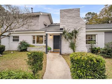 Charming home featuring a textured chimney, well-maintained landscaping, and a welcoming entrance at 718 Parish Rd, Charleston, SC 29407