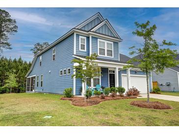 Charming two-story blue home featuring a landscaped yard, attached garage, and welcoming front porch seating at 802 S Pointe Blvd, Summerville, SC 29483