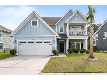Charming two-story home with blue siding, a front porch balcony, and a well-maintained front yard at 8402 Loggers Run, North Charleston, SC 29420