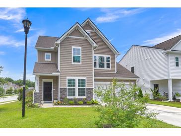 Charming two-story home featuring neutral siding, stone accents, and an attached two-car garage at 9998 Winged Elm St, Ladson, SC 29456