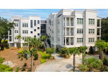 Beautiful white condo building with palm trees and manicured landscaping at 108 Fairbanks Oak Aly # 201, Charleston, SC 29492