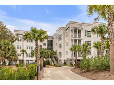 Lowcountry-style condo building with manicured landscaping, mature palms, and covered parking at 108 Fairbanks Oak Aly # 302, Daniel Island, SC 29492