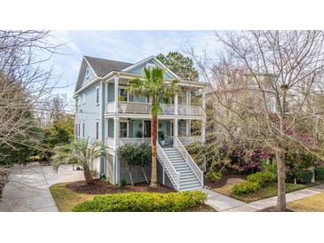 Charming two-story home featuring a double porch, a palm tree, and landscaped yard at 1543 Wando Landing St, Charleston, SC 29492