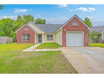 Charming single-Gathering home featuring a brick facade, attached garage, and a well-maintained lawn at 206 Barnwell St, Summerville, SC 29483