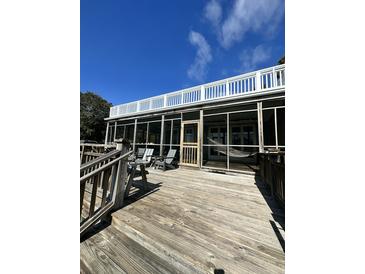 Spacious screened porch with wood floors, comfortable seating, and great views for relaxing and entertaining at 211 Pelican Flight Dr # 1/6Th Share, Dewees Island, SC 29451