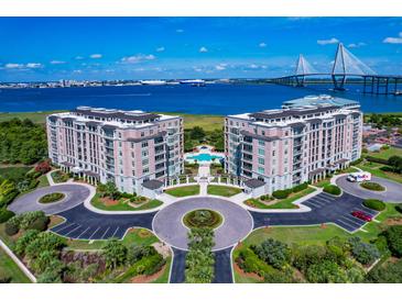 Stunning aerial view of luxury condos with a pool, lush landscaping, and waterfront scenery featuring a majestic bridge at 235 S Plaza Ct Ct # 212, Mount Pleasant, SC 29464