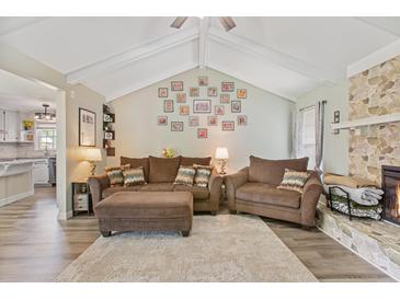 Inviting living room with vaulted ceilings, stone fireplace, and comfortable brown sofa seating at 264 Columbia Dr, Ladson, SC 29456