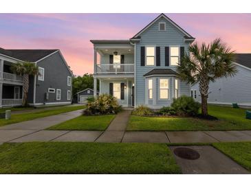 Charming two-story home with a covered front porch, manicured lawn, and lush landscaping at 2881 Rutherford Way, Charleston, SC 29414