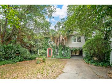Two story home featuring a red door, mature trees, driveway, and partial under-house parking at 3109 Ion Ave, Sullivans Island, SC 29482