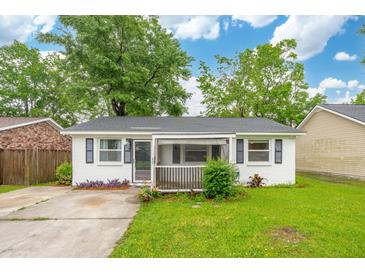 Charming single-story home featuring a well-maintained lawn and a welcoming screened in porch at 40 Elmwood Pl, Goose Creek, SC 29445