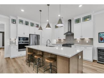 A modern kitchen with stainless steel appliances, a large center island, and pendant lighting at 511 Ocean Mist Way, Summerville, SC 29486