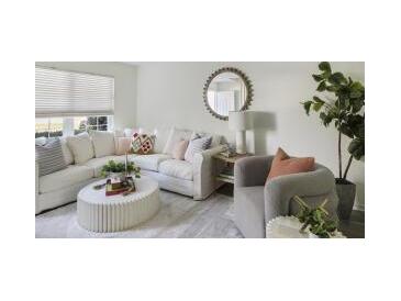 Bright living room with a large sofa, round mirror, plants, and plenty of natural light at 519 Parkdale Dr # J, Charleston, SC 29414