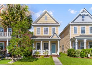 Charming yellow two-story home with a cozy front porch and manicured lawn, exuding curb appeal at 104 Hyacinth St, Summerville, SC 29483