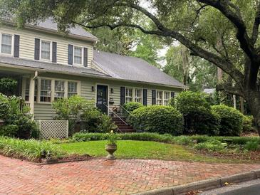 Charming home with a well-manicured lawn, beautiful landscaping, and a brick walkway leading to the entrance at 116 W 5Th South St # D, Summerville, SC 29483