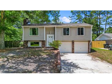 Charming two-story home with a brick and siding exterior, mature trees and attached two-car garage at 117 Canaberry Cir, Summerville, SC 29483