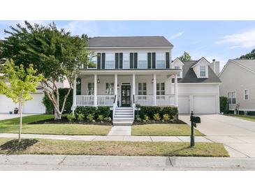 Inviting two-story home featuring a charming front porch, black shutters, and well-maintained landscaping at 1517 Faith St, Mount Pleasant, SC 29466