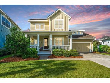 Charming two-story home featuring a welcoming front porch, well-manicured lawn, and attached garage, perfect for a Gathering at 1545 Calaveras Cir, Mount Pleasant, SC 29466