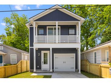 Charming two-story home featuring a spacious garage, a delightful balcony, and a beautifully landscaped front yard at 1989 Groveland Ave, North Charleston, SC 29405