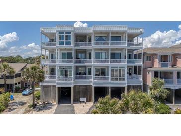 Multi-story condo building with balconies and covered parking spaces below at 216 W Arctic Ave # 9, Folly Beach, SC 29439