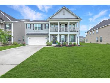 Charming two-story home featuring a double porch, well-manicured lawn, and attached garage at 300 Saxony Loop, Summerville, SC 29486
