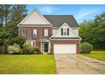 Charming two-story brick home with manicured lawn and attached two-car garage at 317 Sabal Palmetto Ct, Moncks Corner, SC 29461
